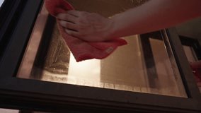 Low-angle view of cleaning service employee spraying window cleaner and using microfiber towel to wipe dirty window on background of sunlight, cleaning and maintaining fresh hygienic environment. - Powered by Shutterstock - Get 15% off with code: PIKWIZARD15