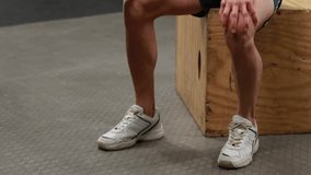 Fitness enthusiast resting elbow on box performing seated dumbbell curls for muscle building in gym. Muscle, strength, training, gym, athlete, performance, health - Powered by Shutterstock - Get 15% off with code: PIKWIZARD15