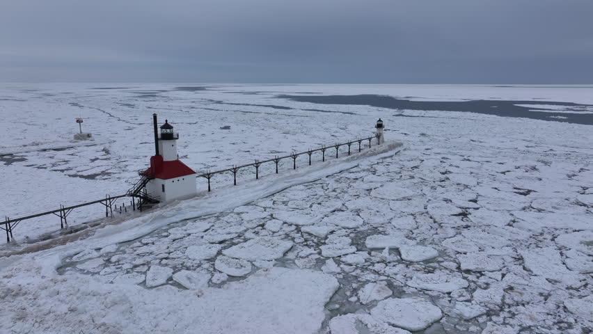 Lighthouse frozen Lake Michigan drone view