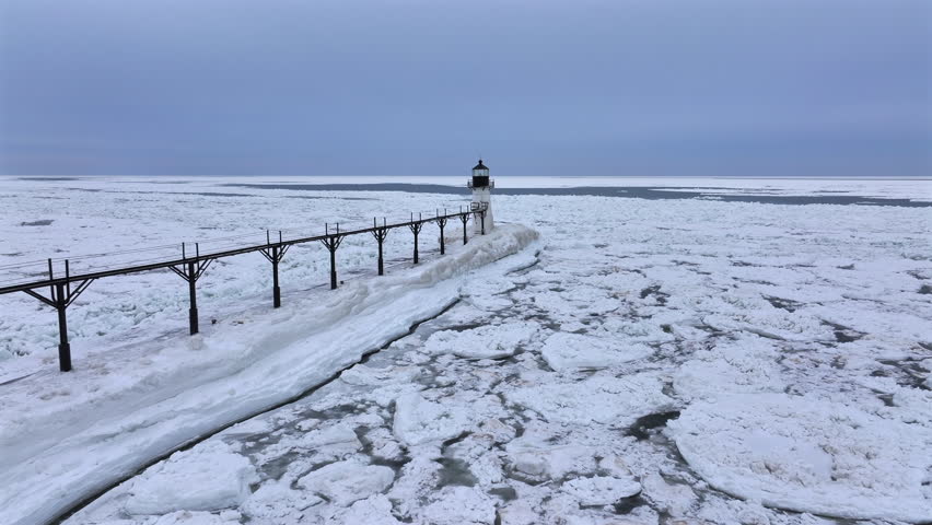 Lighthouse frozen Lake Michigan drone view