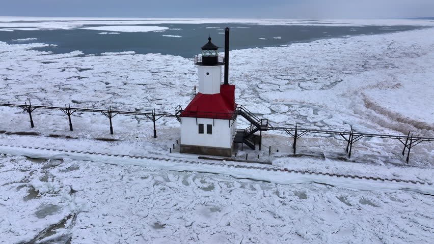 Lighthouse frozen Lake Michigan drone view