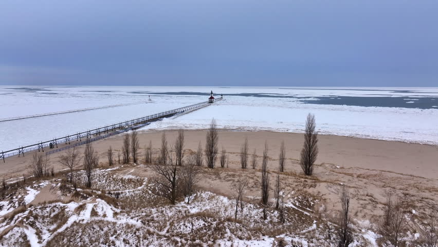 Lighthouse frozen Lake Michigan drone view