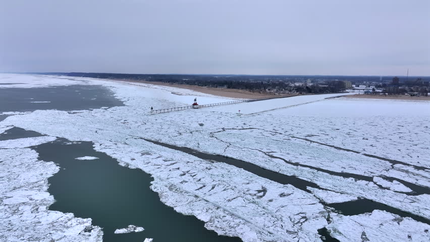 Lighthouse frozen Lake Michigan drone view
