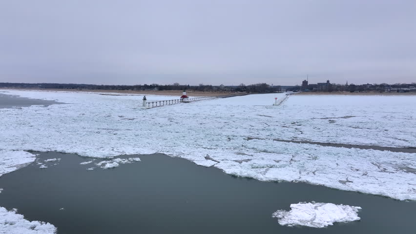 Lighthouse frozen Lake Michigan drone view