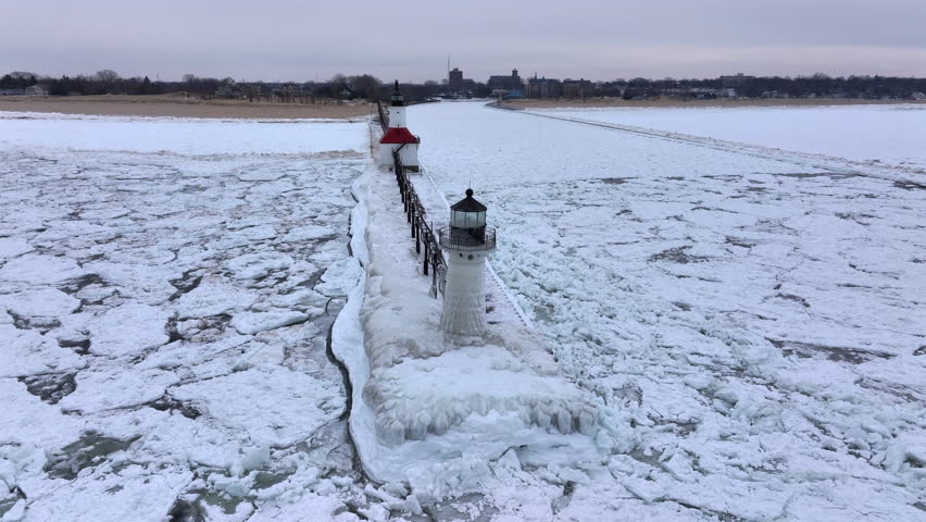 Lighthouse frozen Lake Michigan drone view
