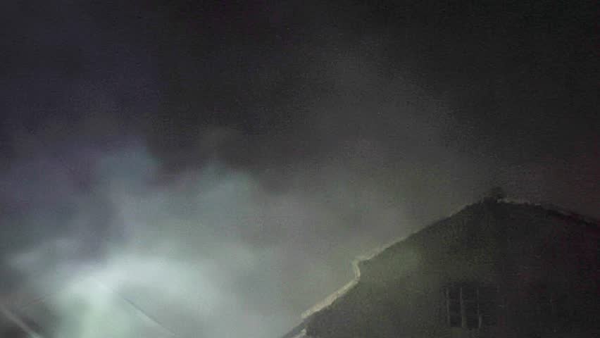 Dark smoky night with heavy mist rising beside a deserted house. Eerie and ghostly ambiance perfect for thriller footage, Halloween elements, or unsettling visual backgrounds.