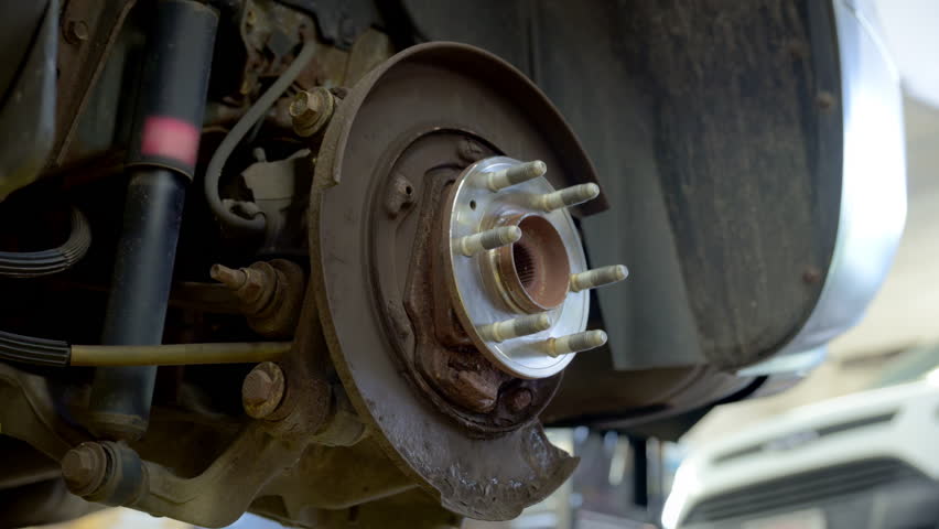 Mechanic instal new brakes rotors. Wheel hub on the car, Various devices in a repair shop