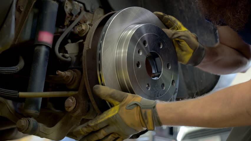 Mechanic instal new brakes rotors. Wheel hub on the car, Various devices in a repair shop