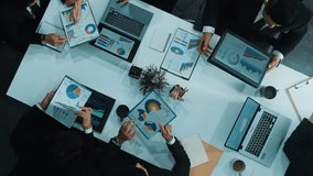 Top down aerial view of business people discussing about financial strategy on table with document and tablet display investment statistic at meeting. Diverse team brainstorm about plan. Directorate. - Powered by Shutterstock - Get 15% off with code: PIKWIZARD15
