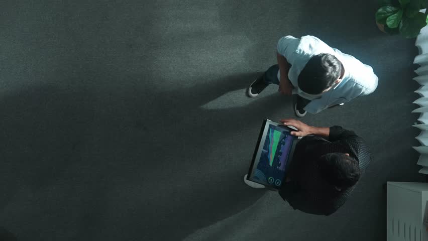 Top down view of business woman walking and presenting business plan by using graph to smart team while standing at meeting room. Investor talking and discuss about marketing strategy. Convocation. - Powered by Shutterstock - Get 15% off with code: PIKWIZARD15