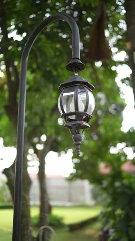 A glowing garden lamp shines warmly with a soft bokeh background in a night setting. Perfect for romantic, cozy, outdoor, evening ambience, lighting, garden decor, and cinematic visuals.