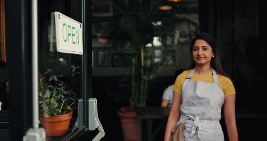 Happy woman, face or waitress at open door in cafe with customer service, welcome and arms crossed. Portrait, confidence and small business owner with smile, hospitality or entrance in coffee shop