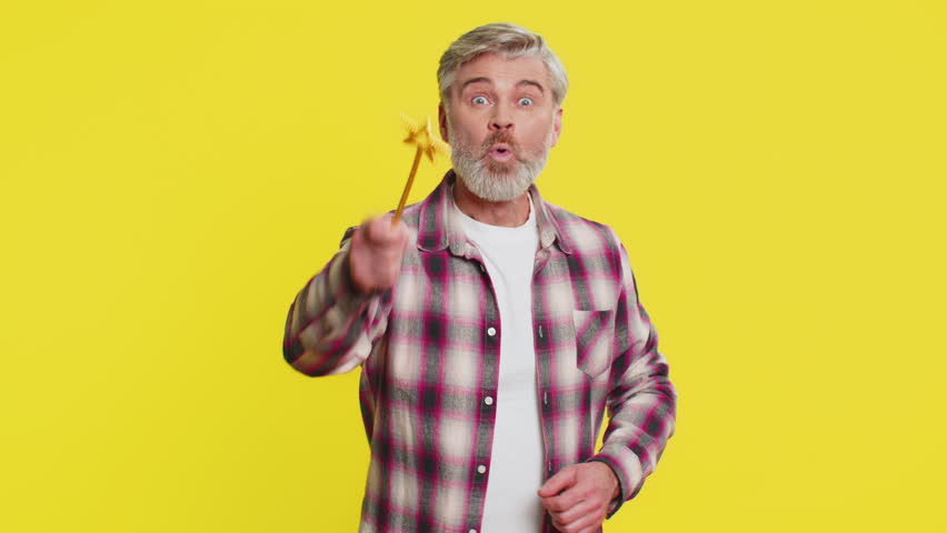Magician witch Caucasian middle-aged man gesturing with magic wand fairy stick, making wish come true, casting magician spell, advertising holidays sale discount. Mature guy on yellow background