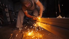 Young repairman in protective mask welding iron construction at garage. Manual laborer with welding machine working at workshop. Male welder operating with metal detail at workplace. Slow motion - Powered by Shutterstock - Get 15% off with code: PIKWIZARD15