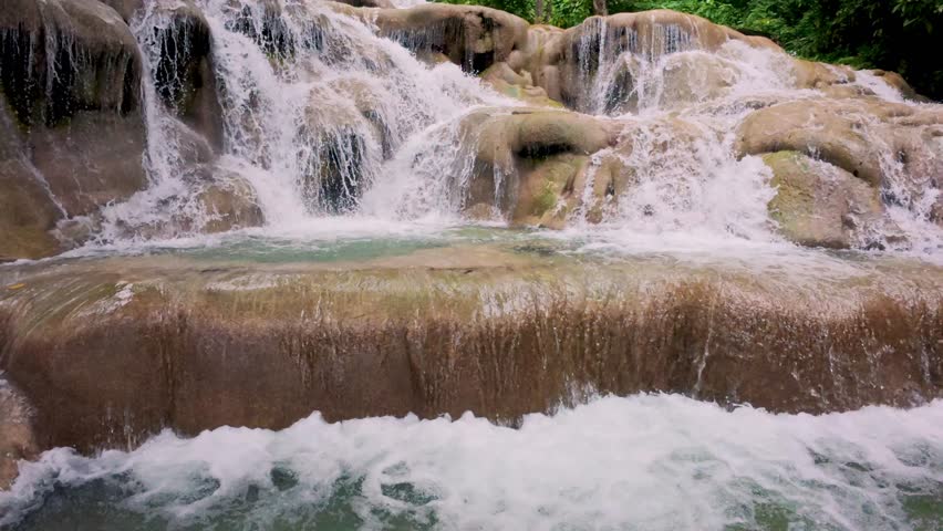 Close up view of Dunn’s River Falls in Jamaica, showcasing cascading water through lush tropical forest.
