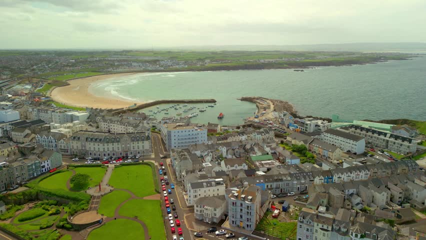 Wide advancing overhead video of West Strand Beach in Portrush in County Antrim in Northern Ireland on a bright and sunny summer day. Produced in 60 frames per second, 4K and with Rec709 color.