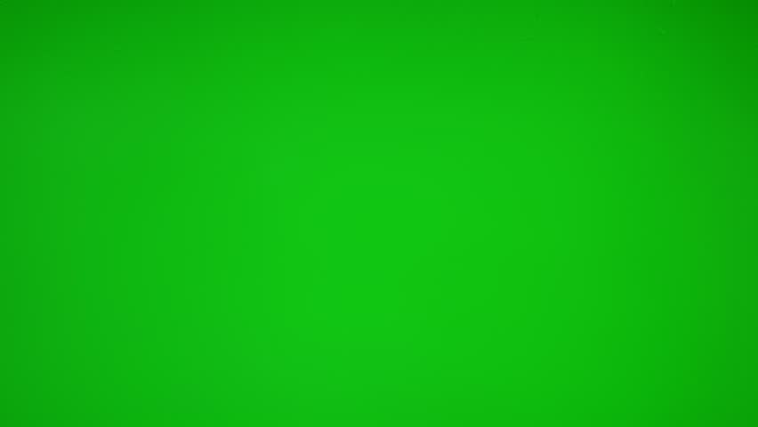 Close up of wet glass with dripping water drops and streaks of rain, on a bright green chroma key background, perfect for visual effects and background replacement.