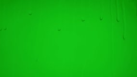 Close up of wet glass with dripping water drops and streaks of rain, on a bright green chroma key background, perfect for visual effects and background replacement. - Powered by Shutterstock - Get 15% off with code: PIKWIZARD15
