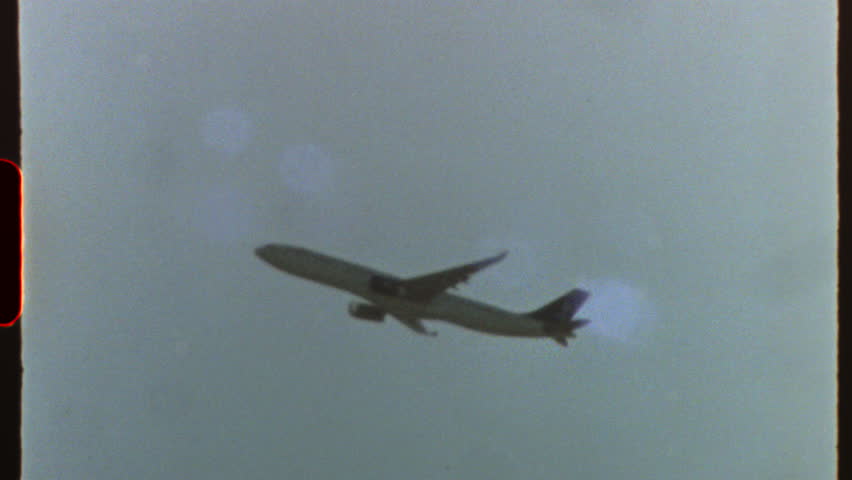 Filmed on super 8 film - airplane flying in the sky with light leaks and film grain, giving a retro and vintage feel, reminiscent of super 8 film