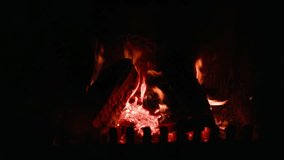 Warm fire slowly burning inside dark fireplace, casting soft flickering light and generating comforting heat, creating serene indoor atmosphere. Glowing logs burning inside stone fireplace - Powered by Shutterstock - Get 15% off with code: PIKWIZARD15