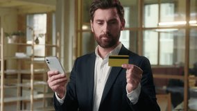 Business smiling Caucasian man paying credit card using mobile phone in office male manager entrepreneur buyer banking app guy ceo leader cashless payment businessman buying online e-commerce finance - Powered by Shutterstock - Get 15% off with code: PIKWIZARD15