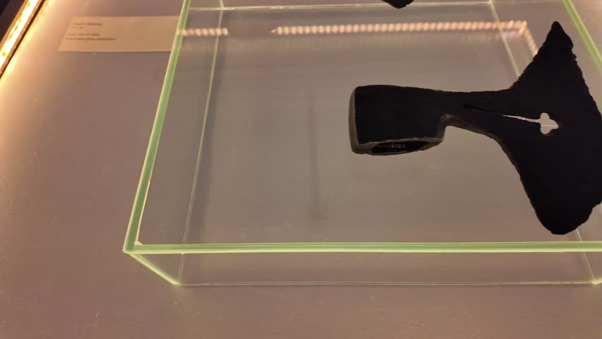 The head of an ancient iron axe in a museum