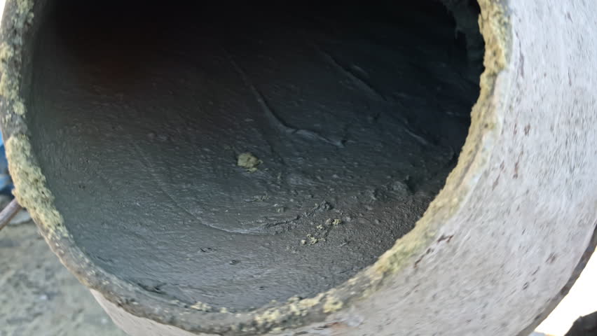 Close-Up of Wet Cement Mixing Inside Drum, Thick Concrete Texture Forming During Construction Process