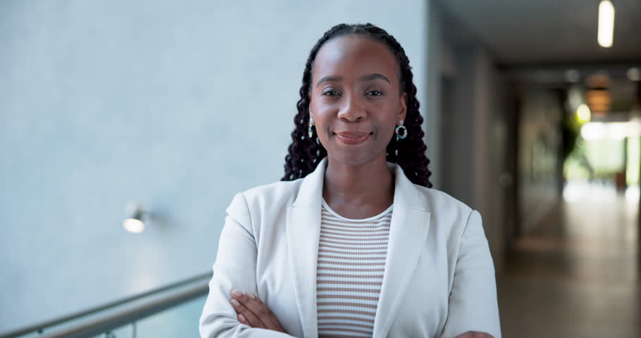 Happy, black woman and face with corporate confidence for entrepreneurship career in office hallway. Portrait, female person or smile with arms crossed for job opportunity or pride in workplace