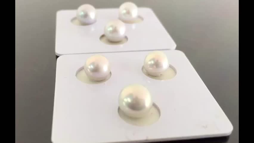 Elegant Display of Shiny White Pearls on Cardboard Background