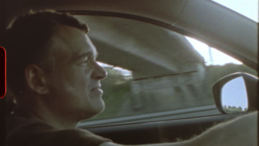 Filmed on super 8 film Light leaks and film grain - a man driving a car, with the sun shining through the windshield