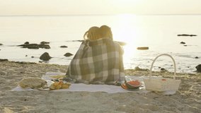 Couple enjoys a romantic sunset picnic by the seaside with serene waves and natural beauty surrounding them - Powered by Shutterstock - Get 15% off with code: PIKWIZARD15