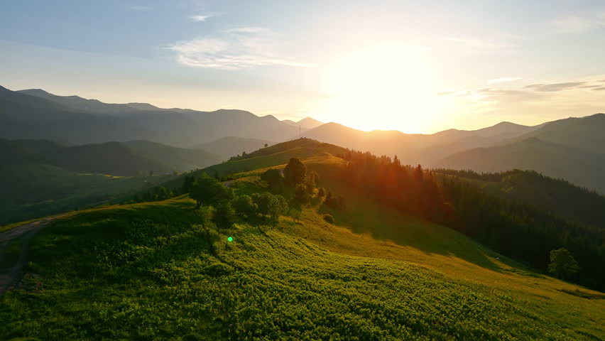Golden Sunset Over Mountain Ridge, Aerial Landscape With Rolling Hills and Trees Bathed in Warm Evening Light