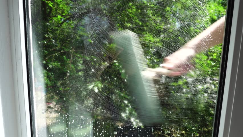 Housewife Cleaning Windows With Foam. Chores Sponge Cleaning Window Glass. Equipment For Washing. Cleanliness Care Maintenance. Household Chores Windows Cleaning Rag Glass Cleaner Detergent Soap Suds