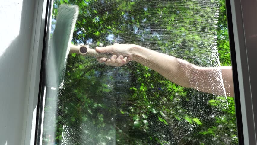 Housewife Cleaning Windows With Foam. Chores Sponge Cleaning Window Glass. Equipment For Washing. Cleanliness Care Maintenance. Household Chores Windows Cleaning Rag Glass Cleaner Detergent Soap Suds