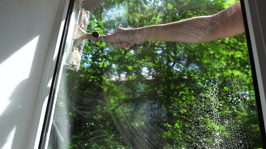 Housewife Cleaning Windows With Foam. Chores Sponge Cleaning Window Glass. Equipment For Washing. Cleanliness Care Maintenance. Household Chores Windows Cleaning Rag Glass Cleaner Detergent Soap Suds