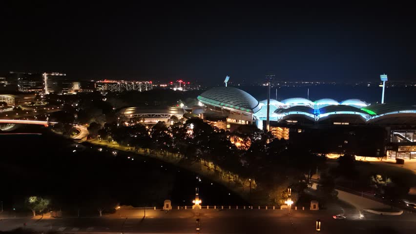 Adelaide City, South Australia, 2 Jul 2025: 4K Aerial Drone Footage Capturing Night Skyline, Adelaide Oval, Festival Plaza, Riverbank Precinct, Footbridge, Illuminated Buildings, Traffic Lights and