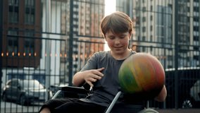Teenage boy with special needs who uses wheelchair throws ball into basketball basket, scoring point. He is so happy about his success that he smiles widely, celebrating his victory. - Powered by Shutterstock - Get 15% off with code: PIKWIZARD15