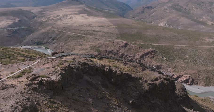 Aerial view of La Puntilla lookout platform overlooking a valley with Neuquen river and distant mountains. Neuquen, Argentina
