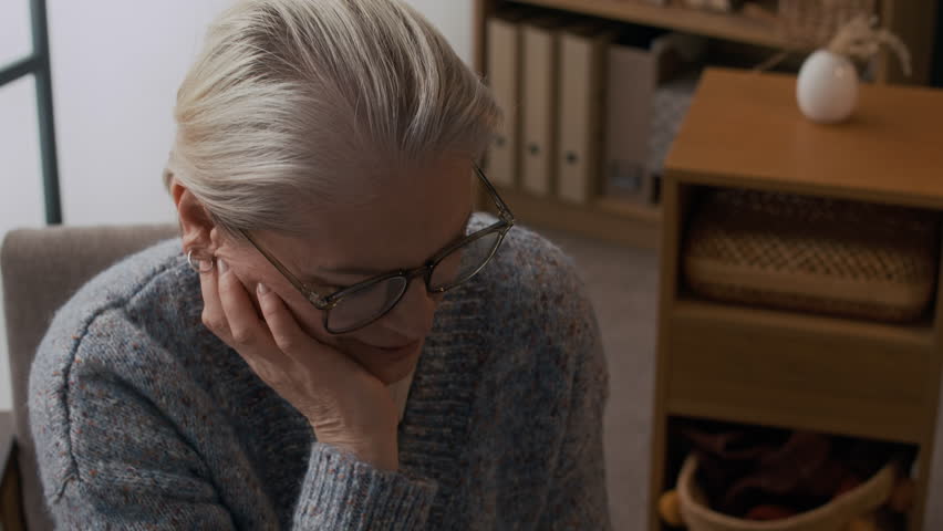 Tilt down shot of mature psychologist listening to male patient lying on couch in VR headset touching fake spider and overcoming arachnophobia during individual therapy session