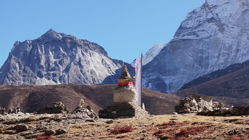 A serene landscape in the Himalayas of Nepal, featuring a stupa-like structure against a backdrop of majestic snow-capped mountains