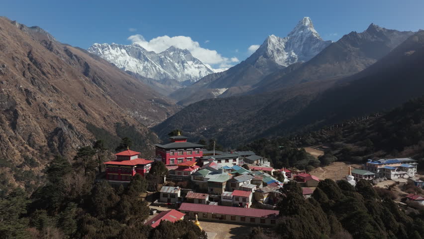 Aerial view of Tengboche Monastery nestled in the Himalayas of Nepal, showcasing traditional architecture and a majestic snow-capped peak in the background