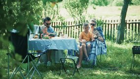 happy family relaxing in garden. happy family enjoys relaxed outdoor picnic in lush green garden with parents children gathered around table. family time and summer leisure. Family picnic on fresh air - Powered by Shutterstock - Get 15% off with code: PIKWIZARD15