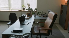 Background shot of psychotherapists workspace equipped with laptop and leather upholstery armchair at desk in modern counselling office with green plants, copy space - Powered by Shutterstock - Get 15% off with code: PIKWIZARD15
