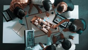 Top down view of manager pointing at house model and explain building design. Aerial view of architect engineer brainstorming about interior construction while tablet display house plan. Alimentation. - Powered by Shutterstock - Get 15% off with code: PIKWIZARD15