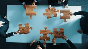 Skilled business people putting puzzle together at meeting table. Group of smart diverse business team connect or solve problem together. Team building, teamwork or unity concept. Directorate. - Powered by Shutterstock - Get 15% off with code: PIKWIZARD15