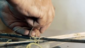 Senior Man Tying Wooden Sticks and String While Making a Kite for His Grandson at Home - Closeup Shot - 4K - Powered by Shutterstock - Get 15% off with code: PIKWIZARD15