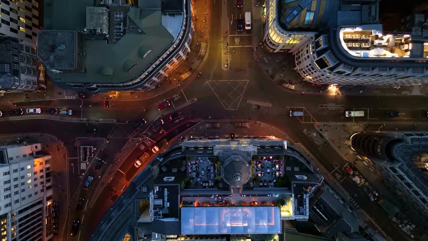 Aerial top down view of the illuminated streets at the City of London, England, during dusk with car and pedestrian traffic