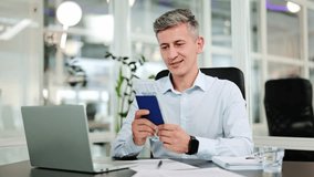 Successful businessman in a light shirt happily holds passport and money, dreaming of future international travel. Planning global adventures from modern office desk, filled with optimism. - Powered by Shutterstock - Get 15% off with code: PIKWIZARD15
