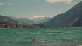 Happy young couple man and woman swimming hanging out in sea laughing hugging having fun. summer background blue sky lake mountains Switzerland. slow motion splashes waves Turquoise Water Brienzersee - Powered by Shutterstock - Get 15% off with code: PIKWIZARD15