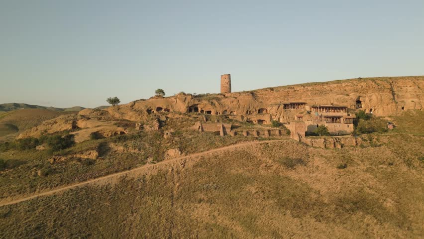 Aerial view Natlismtsemeli Monastery complex carved into cliffs, medieval Georgian Orthodox architecture in remote Kakheti hills. Part of David Gareja monastic complex. Azerbaijan Georgia border zone